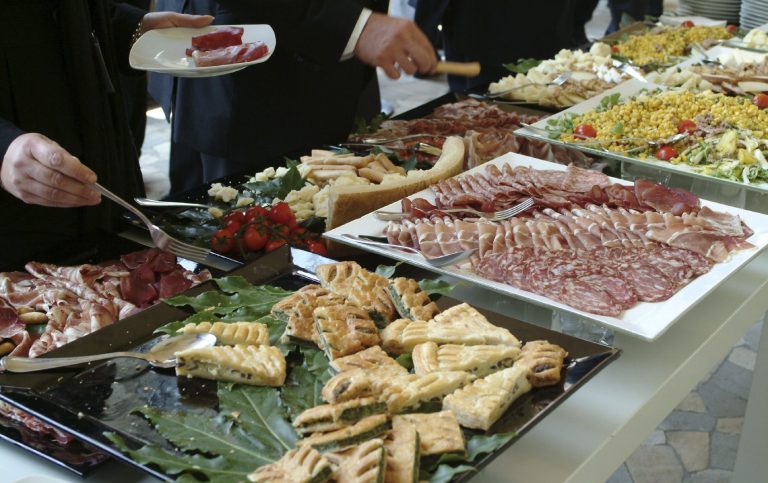 Firmenfeier-Catering mit einem Businessbuffet: Platten mit verschiedenen Fleisch- und Käsesorten, belegten Brötchen und Salaten.