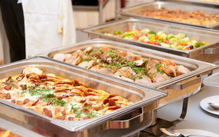 Ein reichhaltiges warmes Buffet von Al-Layal Catering mit verschiedenen Hauptgerichten und Beilagen in Wärmebehältern.
