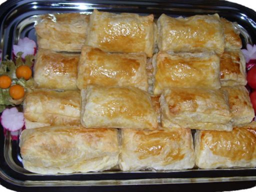 Goldbraune Blätterteigtaschen mit cremiger Käsefüllung, appetitlich gestapelt.