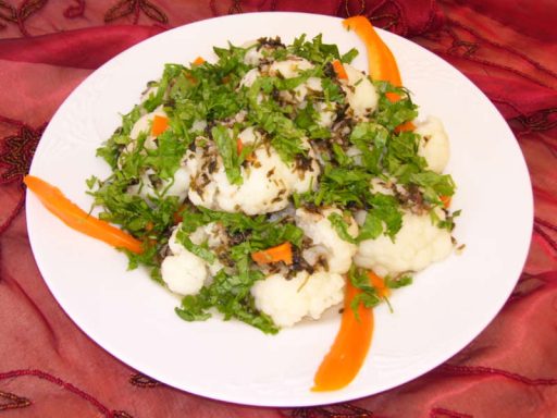 Gerösteter Blumenkohlsalat mit frischer Petersilie, vegan angerichtet.