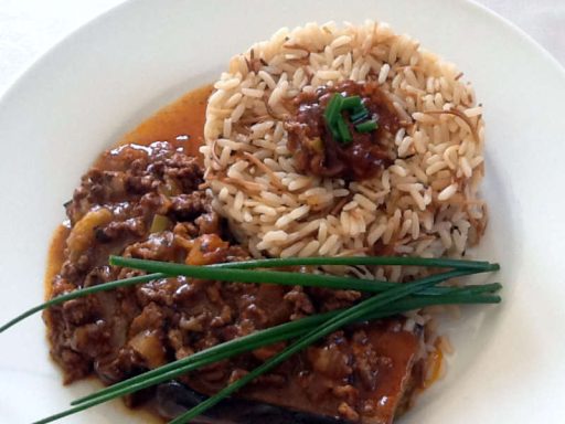 Halbe Aubergine gefüllt mit Hackfleisch und Pinienkernen, in Tomatensoße gebacken.