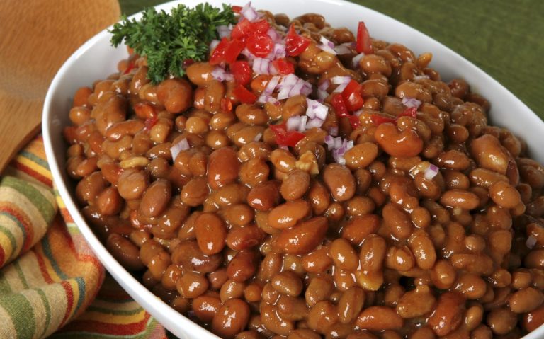 Veganes Catering Berlin mit Bohnen in einer Schüssel, garniert mit Tomaten und Zwiebeln.
