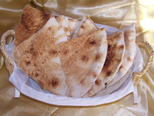 Frisch gebackenes arabisches Fladenbrot, in Stücke geschnitten und bereit zum Servieren mit Dips und Hauptspeisen.