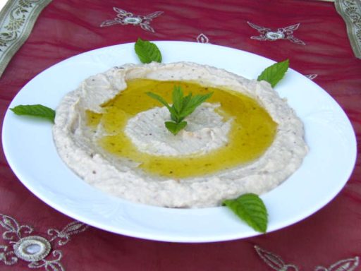 Cremiger Mutabal-Auberginen-Dip, garniert mit Olivenöl und Petersilie, als vegane Beilage oder Hauptkomponente für Ihr Catering.
