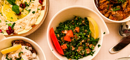 Exklusives Catering Berlin: verschiedene Schalen mit Salat, Hummus, gefülltem Gemüse und einem herzhaften Gericht.