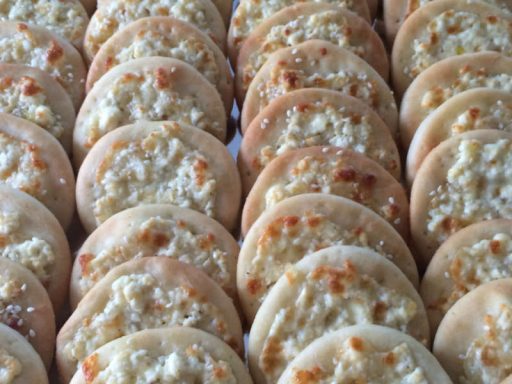 Kleine Kräuter-Käse-Partypizza-Stücke, ideal als vegetarisches Fingerfood.
