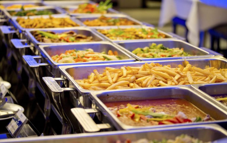 Private Feier Catering mit vielfältigen Speisen in Buffetwärmern, darunter Gemüse, Pommes und Saucen.