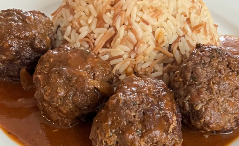 Catering-Angebote Berlin mit Fleischbällchen in Sauce und einer Beilage aus Reis.