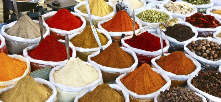 Exklusives Catering Berlin: Bunte Gewürze in Säcken auf einem Markt, in verschiedenen Farben und Texturen.