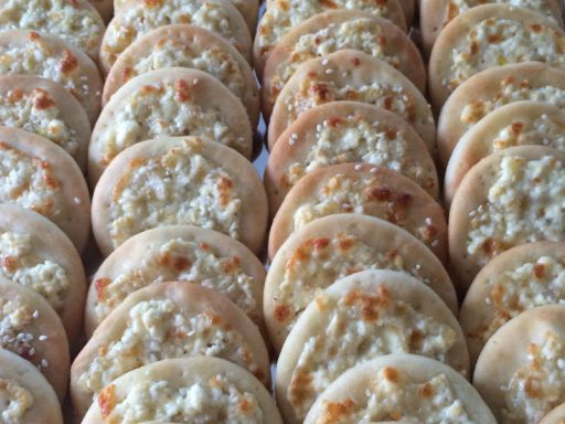 Kleine Käsepartypizza-Stücke als Fingerfood, ideal für Partys und Buffets.