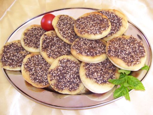 Kleine Kräuterpartypizza-Stücke auf arabischem Fladenbrot, reich belegt und ideal als veganes Fingerfood für Partys in Berlin.