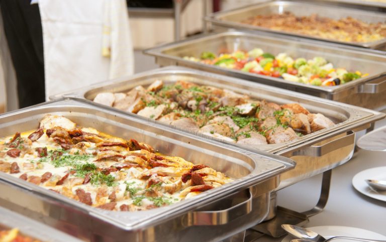Ihr libanesisches Hochzeitscatering: ein Buffet mit verschiedenen warmen Speisen, darunter Fleisch und bunte Gemüsegerichte.