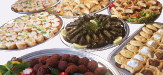 Exklusives Catering Berlin: Verschiedene Platten mit libanesischen Speisen, darunter Fleischbällchen und Teigbällchen.