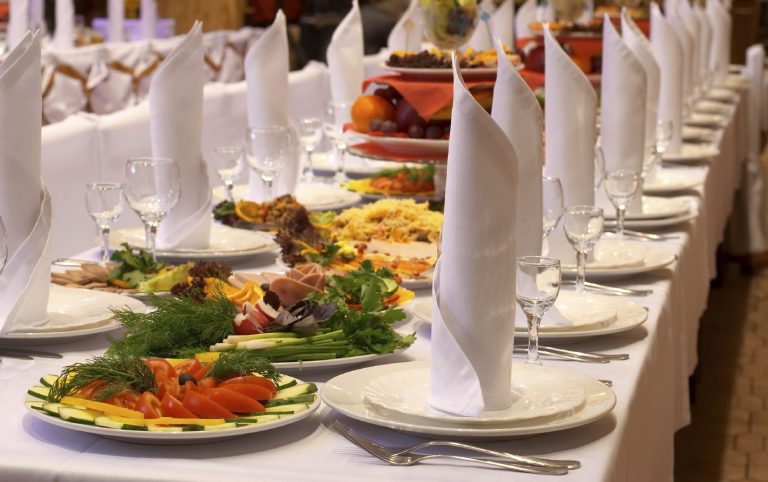 Hochzeit-Catering Berlin mit festlich gedecktem Tisch und verschiedenen Speisen.