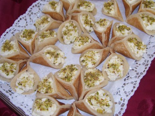 Gefüllte Atayef-Pfannkuchen mit Achtacreme, knusprig gebacken und gesüßt, ein orientalisches vegetarisches Dessert.