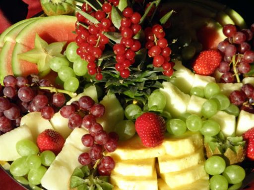 Eine farbenfrohe und reichhaltige orientalische Fruchtplatte mit einer Auswahl an frischem, geschnittenem Obst, ideal für veganes Catering.
