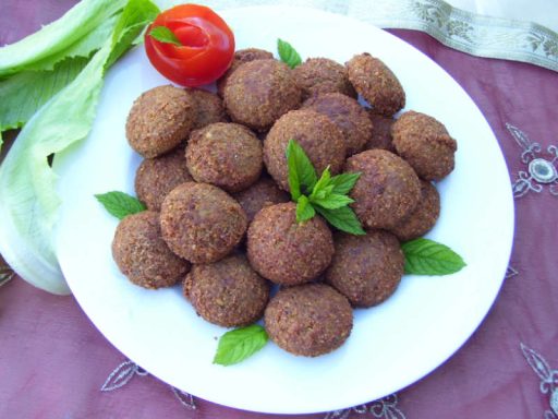 Knusprige Falafel-Bällchen, optional serviert mit frischem Gemüse und Tahini-Sauce, als beliebte vegane Hauptspeise für Ihr Catering.