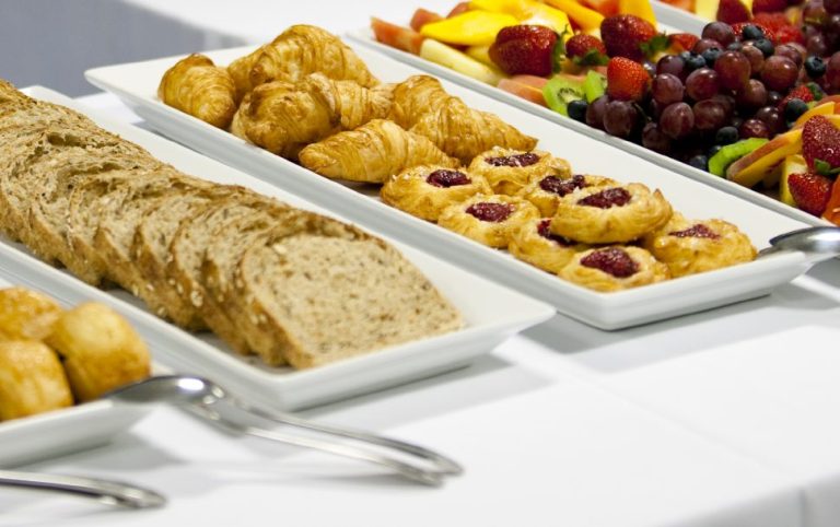 Premium-Catering Berlin mit Buffet, Gebäck, Brot und einer Auswahl an frischen Früchten.