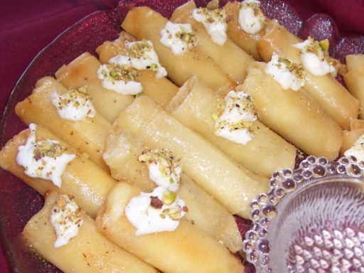Knusprige Znoud el Sit, gefüllt mit cremiger Füllung und in Sirup getaucht, ein luxuriöses orientalisches Dessert.