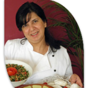 Libanesisches Hochzeitscatering: Eine lächelnde Köchin hält eine Schüssel mit Salat und einen Teller mit gefüllten Teigtaschen.
