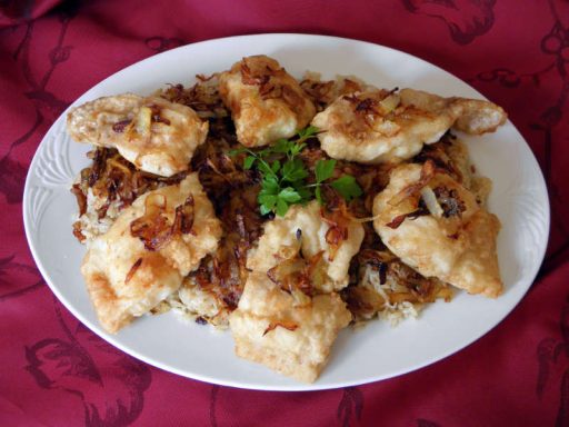 Teller mit aromatischem Reis und Fischfilet, garniert mit Pinienkernen.