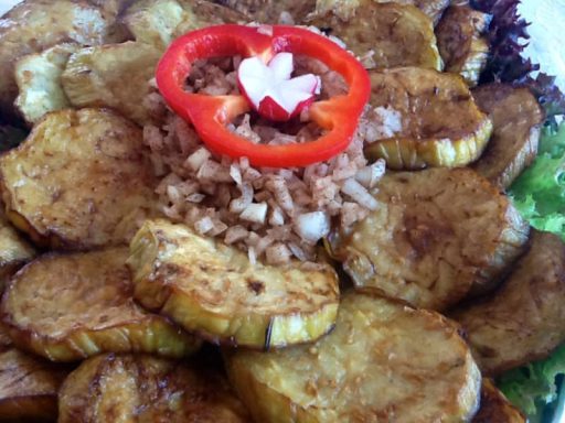 Goldbraun gebratene Auberginenscheiben, zart und aromatisch, als vegane Beilage oder Bestandteil eines orientalischen Buffets.