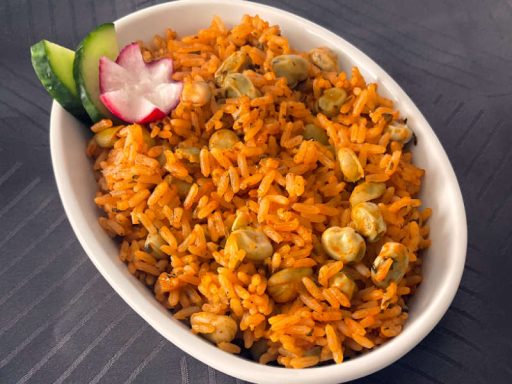Hausgemachter Reis mit grünen Bohnen in würziger Tomatensauce, als nahrhafte vegane Hauptspeise für orientalisches Catering.