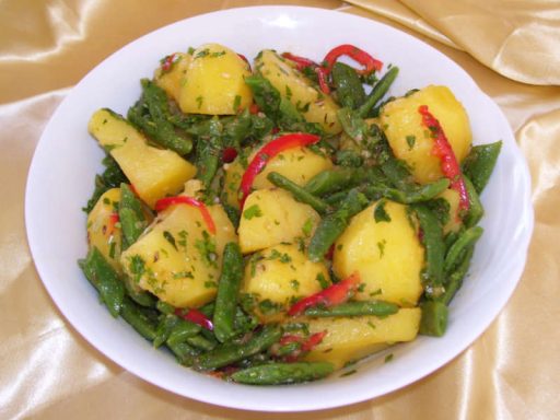 Orientalisch gewürzter pikanter Kartoffelsalat mit Kräutern und Oliven, als vegane Spezialität.