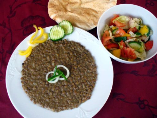 Traditionelle Megadara, ein veganes Gericht aus Reis und Linsen, getoppt mit knusprigen karamellisierten Zwiebeln, als Hauptspeise.