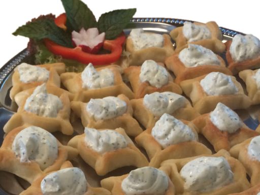 Kleine eckige Teigtaschen (Swiha) mit einer herzhaften vegetarischen Füllung, gebacken und appetitlich präsentiert.