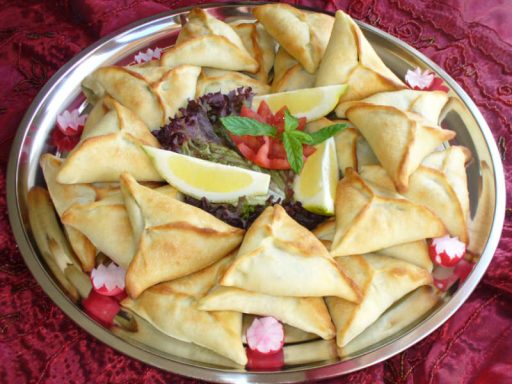 Kleine, dreieckige Fattayer-Teigtaschen mit würziger Spinatfüllung, als veganes orientalisches Fingerfood.