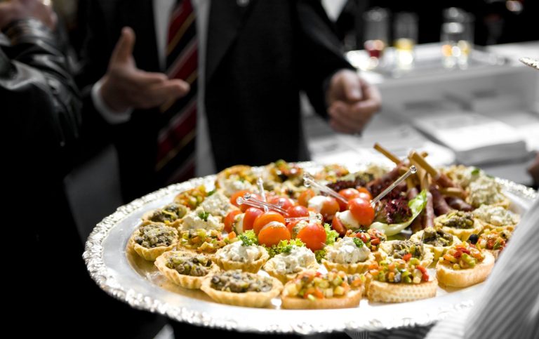 Firmenfeier-Catering mit einem Businessbuffet: Fingerfood-Häppchen und Cocktailtomaten.