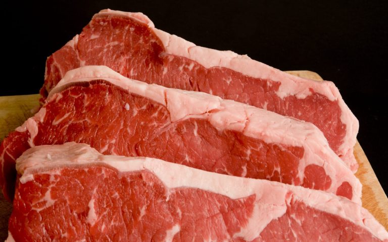 Halal-Catering Berlin mit drei Stücken rotem Fleisch mit deutlicher Marmorierung und fettem Rand.