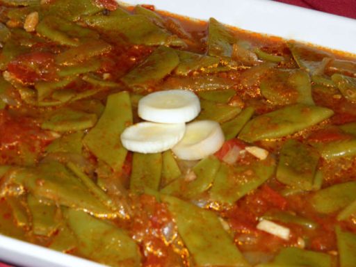 Zarte grüne Bohnen (Lubje Belsait) in einer würzigen Tomaten-Knoblauch-Sauce, als vegane Hauptspeise oder Beilage.
