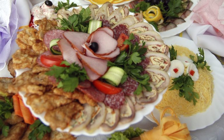 Firmenfeier-Catering mit einem reichhaltigen Buffet mit verschiedenen Fleisch- und Käseplatten sowie frischem Gemüse.
