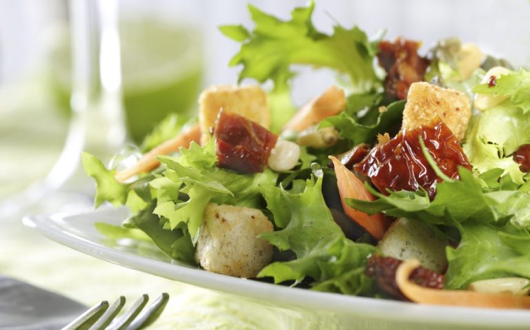 Vegetarisches Catering Berlin mit frischem Salat mit grünen Blättern, getrockneten Tomaten und Croutons.